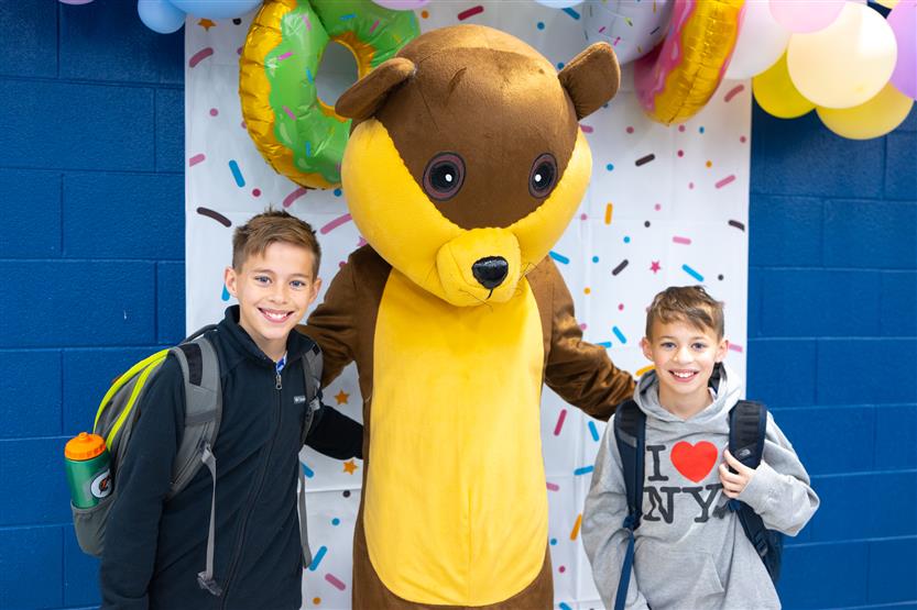 Creekside Elementary students eat donuts with a grown-up